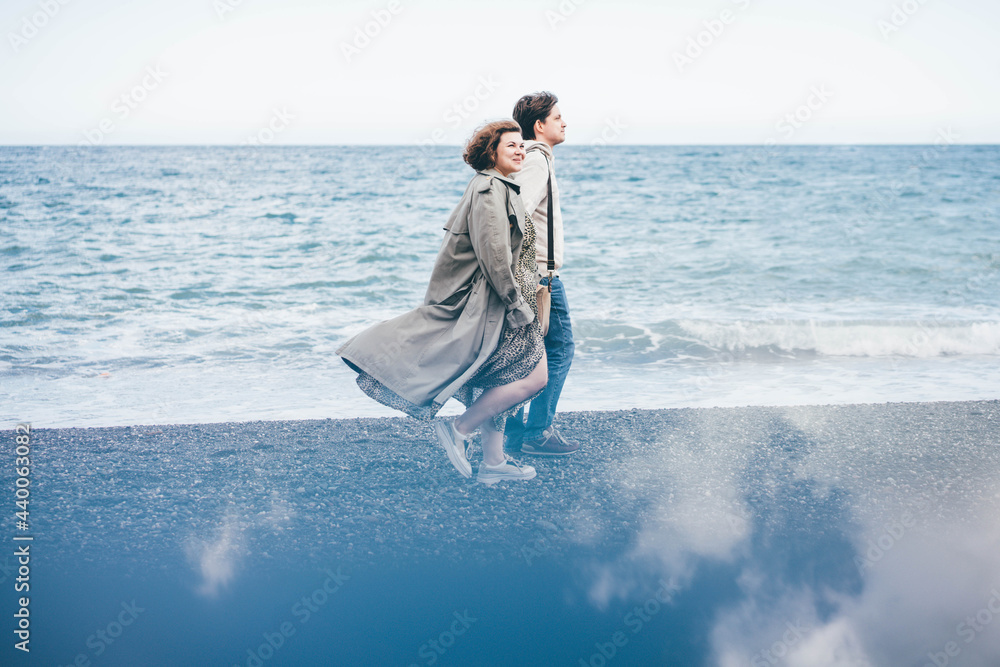  Couple in love walks by the sea. 