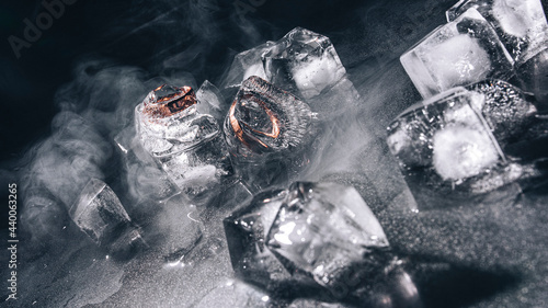 Rings frozen in ice with water and smoke on black background (ID: 440063265)