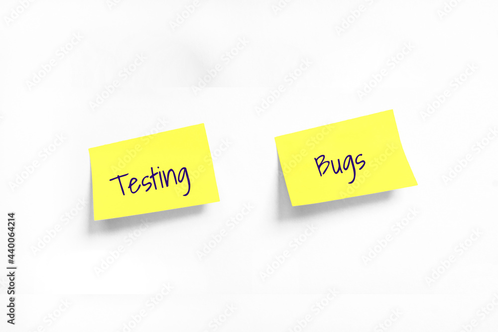 Two Yellow stickers with Testing and Bugs text on white Whatman paper. Concept learn, starting education. Handwriting text close up isolated, copy space Two Yellow stickers with Testing and Bugs text on white Whatman paper. Concept learn, starting education. Handwriting text close up isolated, copy space