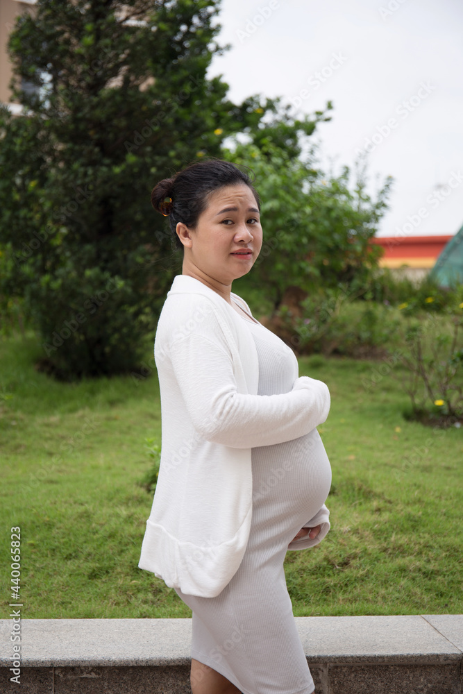 Fototapeta premium Asian Pregnant Woman walking in the park in the morning
