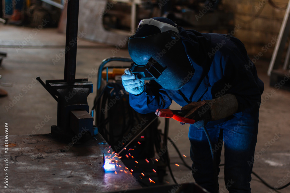 Skillful welders weld steel in the factory. Construction site metal welder. Skillful welders weld steel in the factory. Construction site metal welder.