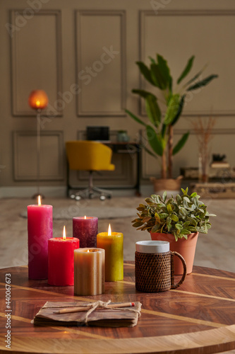 Colorful candle close up concept with coffee wicker glass on the wooden desk  decorative working table computer and chair lamp background.