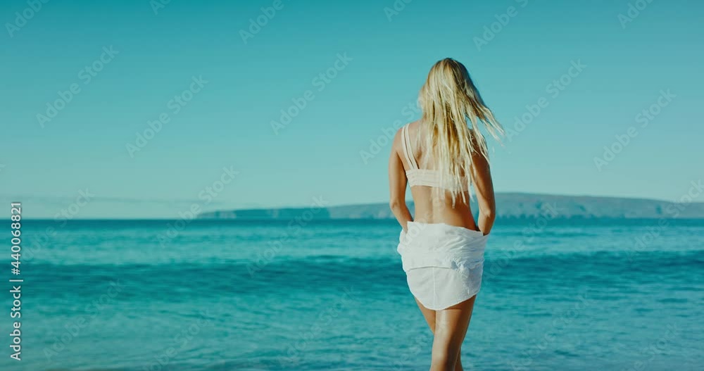 Happy attractive young woman enjoying morning walk down the beach at sunrise on vacation, healthy morning lifestyle Happy attractive young woman enjoying morning walk down the beach at sunrise on vacation, healthy morning lifestyle