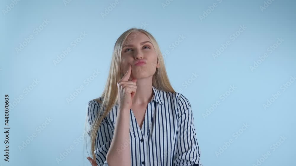 Cheerful blonde woman coming to an excellent idea after a minute of thinking on blue background. Cheerful blonde woman coming to an excellent idea after a minute of thinking on blue background.