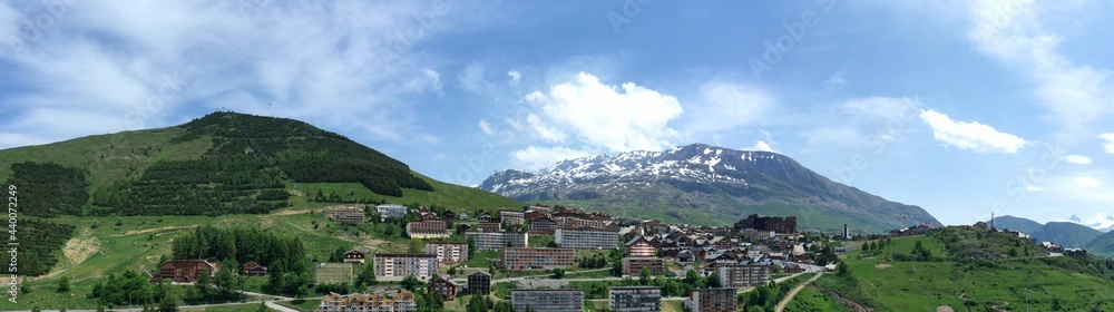Panoramique de l'Alpe d'Huez en Oisans, la station et les pistes de ski en été avec un drone
