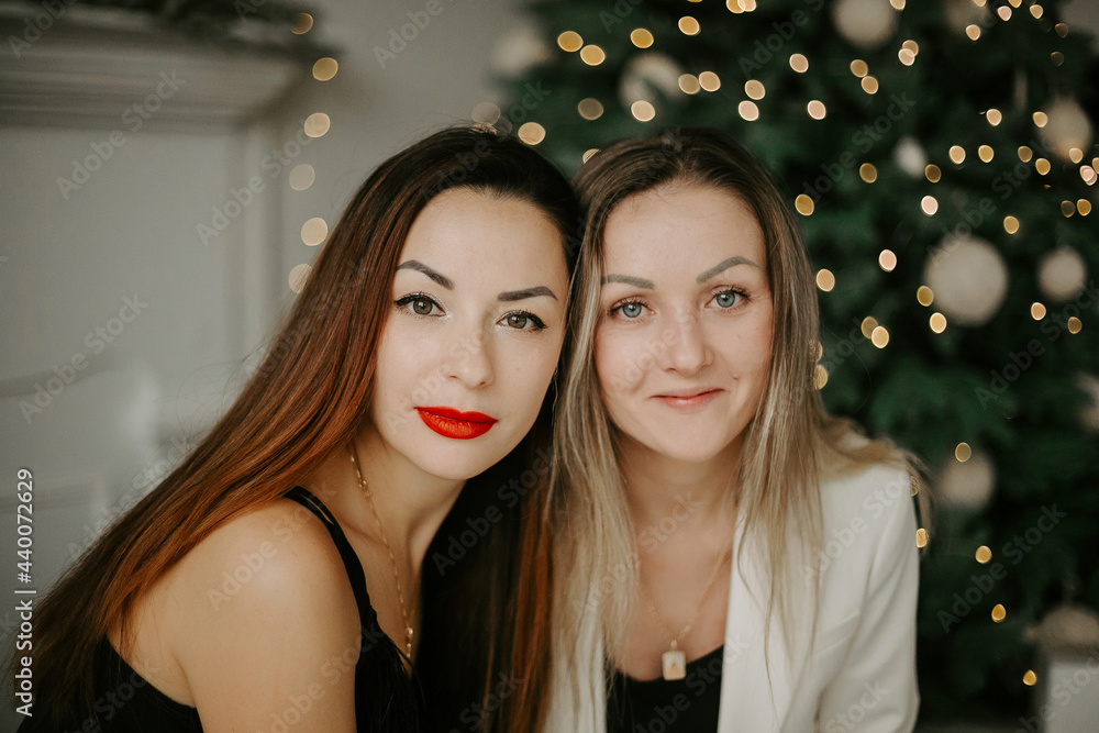 Front view of two young women looking at camera on the lights background. Front view of two young women looking at camera on the lights background.