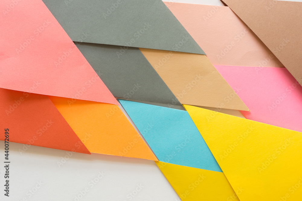 triangle-shaped folded construction paper background - orange red yellow pink grey brown tan sand
