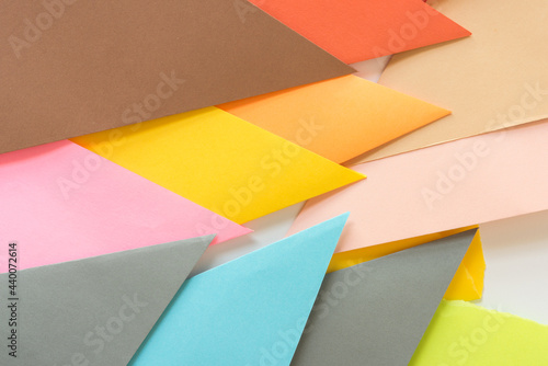 triangle-shaped folded construction paper background - pointy angular shapes in blue grey pink yellow orange red and brown