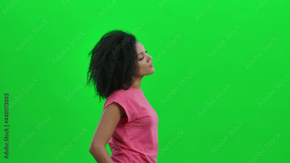 Side view of young female African American considering something. Black woman with curly hair poses on green screen in the studio. Close up. Slow motion ready 59.97fps. Side view of young female African American considering something. Black woman with curly hair poses on green screen in the studio. Close up. Slow motion ready 59.97fps.