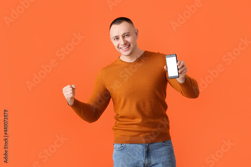 Happy young man with mobile...