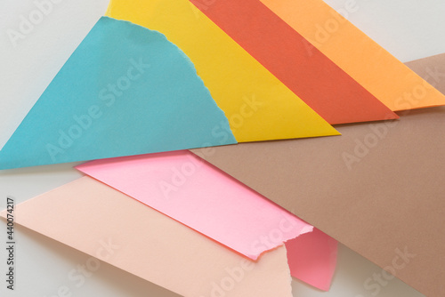 triangle-shaped folded construction paper background in blue yellow orange brown pink and sand