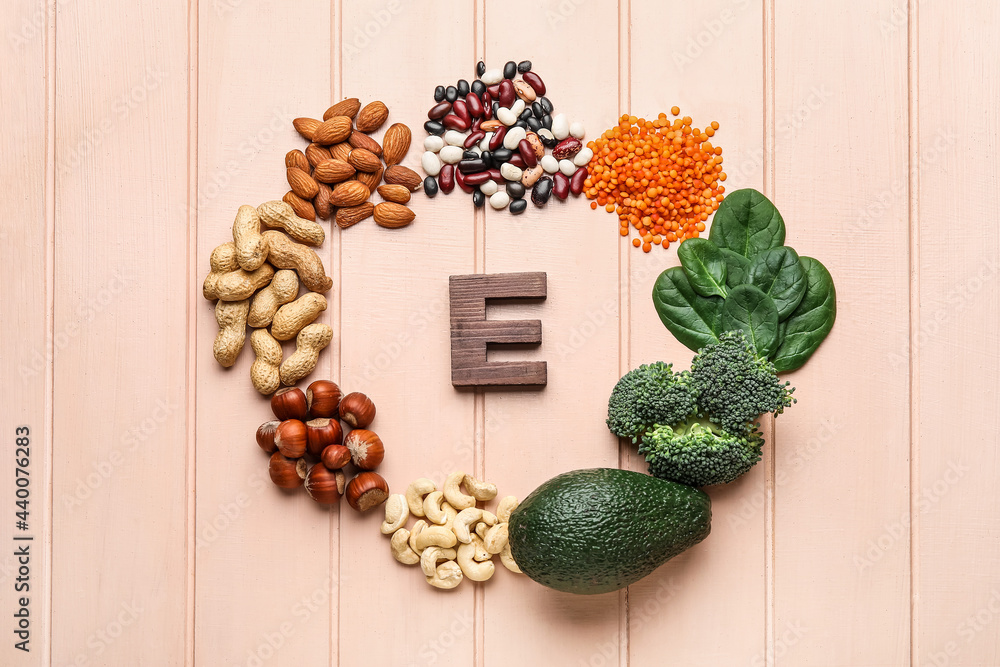 Frame made of healthy products rich in vitamin E on color wooden background
