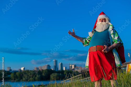 Santa Claus in a Hawaiian shirt is walking in nature. Christmas in the tropics