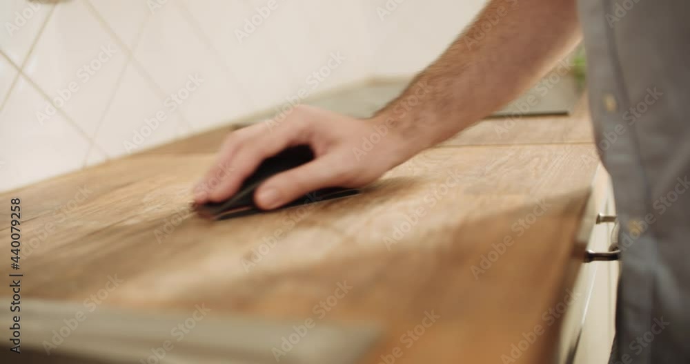 DIY Man sanding a kitchen countertop manually DIY Man sanding a kitchen countertop manually