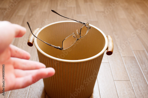 合わなくなり不要になったメガネをゴミ箱へ投げ捨てる
