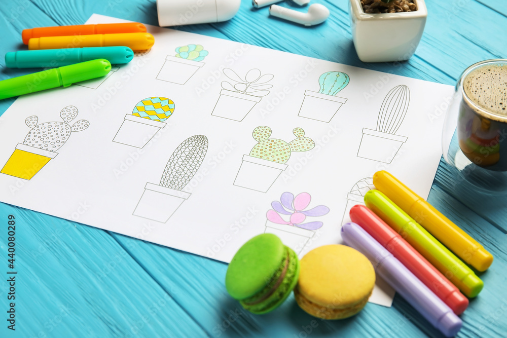 Coloring picture, macaroons and felt-tip pens on wooden background Coloring picture, macaroons and felt-tip pens on wooden background