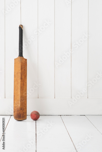 Cricket bat against wall.