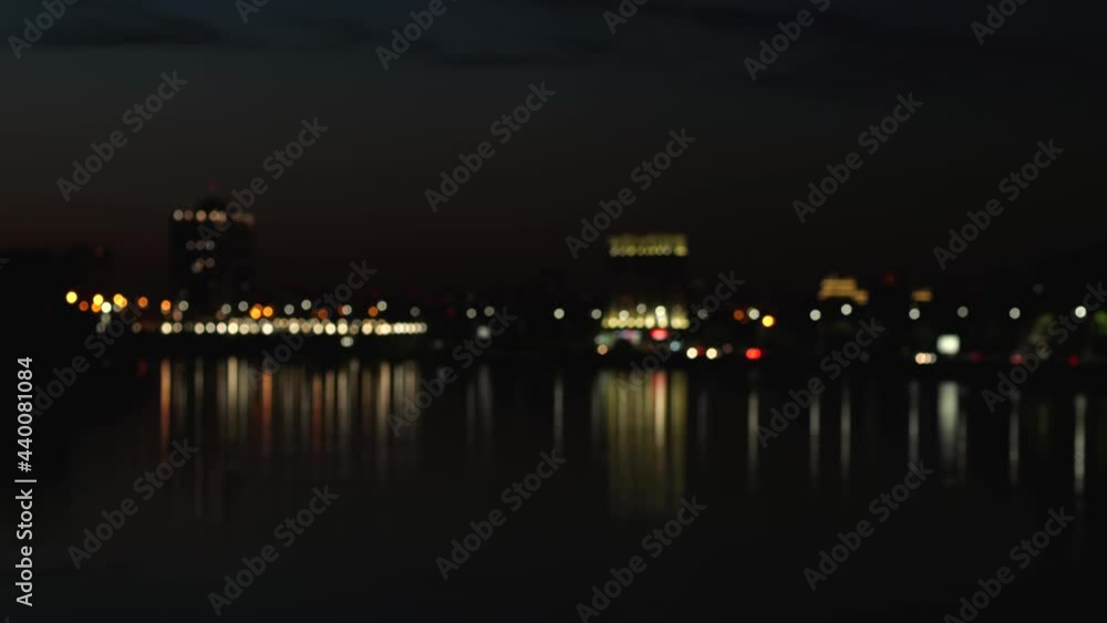 The blurred lights of the evening city are reflected in the river. Nightlife in the metropolis The blurred lights of the evening city are reflected in the river. Nightlife in the metropolis