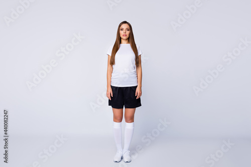 Full length photo of serious lady skilled player soccer women team stand calm listen coach advice wear football uniform t-shirt shorts long socks shoes isolated white color background