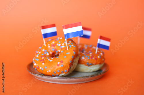 Orange donuts with Dutch flags. Donuts made to celebrate King's Day or support Dutch national soccer team.