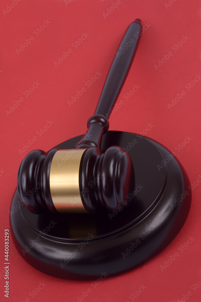 Marteau de juge en gros plan sur fond rouge Marteau de juge en gros plan sur fond rouge