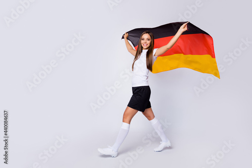 Full body photo of fan lady raise german flag support nation country world soccer league cup walk stadium wear football uniform t-shirt shorts shoes socks isolated white color background
