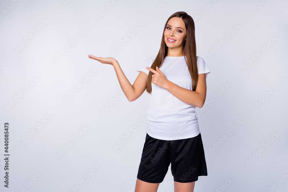 Photo of pretty sports lady raise hand hold novelty soccer sportswear product direct finger advising buy low price wear football uniform t-shirt shorts isolated white color background Photo of pretty sports lady raise hand hold novelty soccer sportswear product direct finger advising buy low price wear football uniform t-shirt shorts isolated white color background