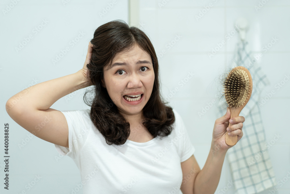 Asian young woman worried about hair fall problem. Asian young woman worried about hair fall problem.