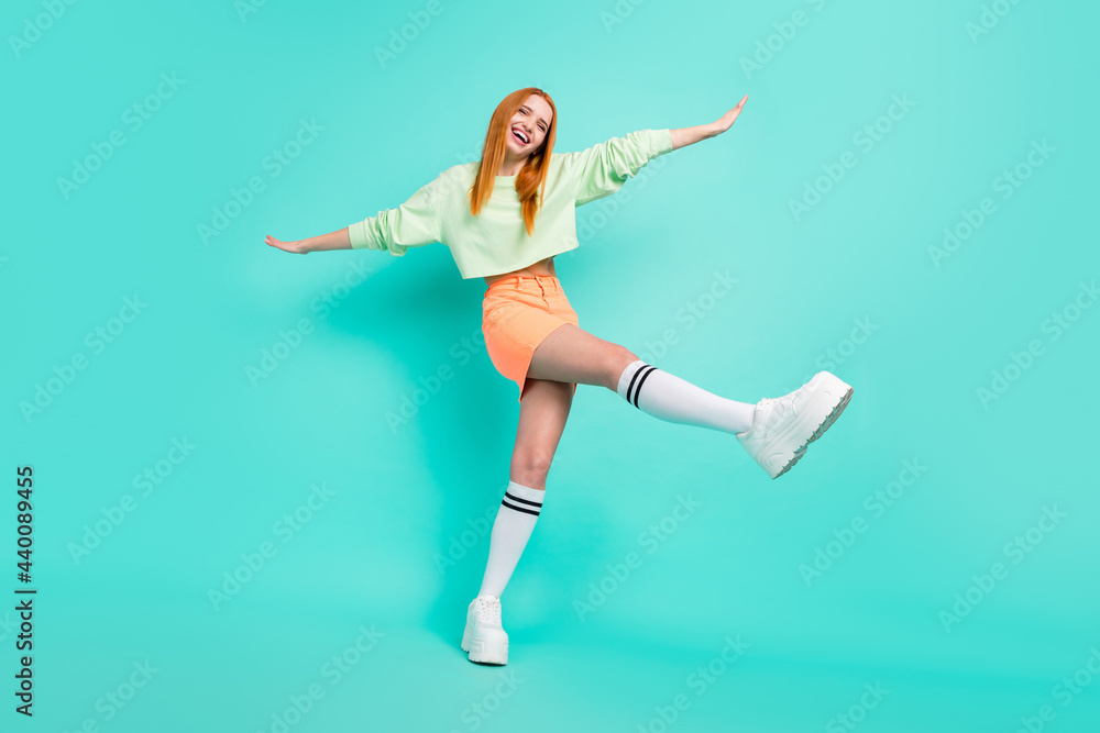 Full body photo of crazy millennial lady fly wear sport clothes skirt shoes isolated on teal color background