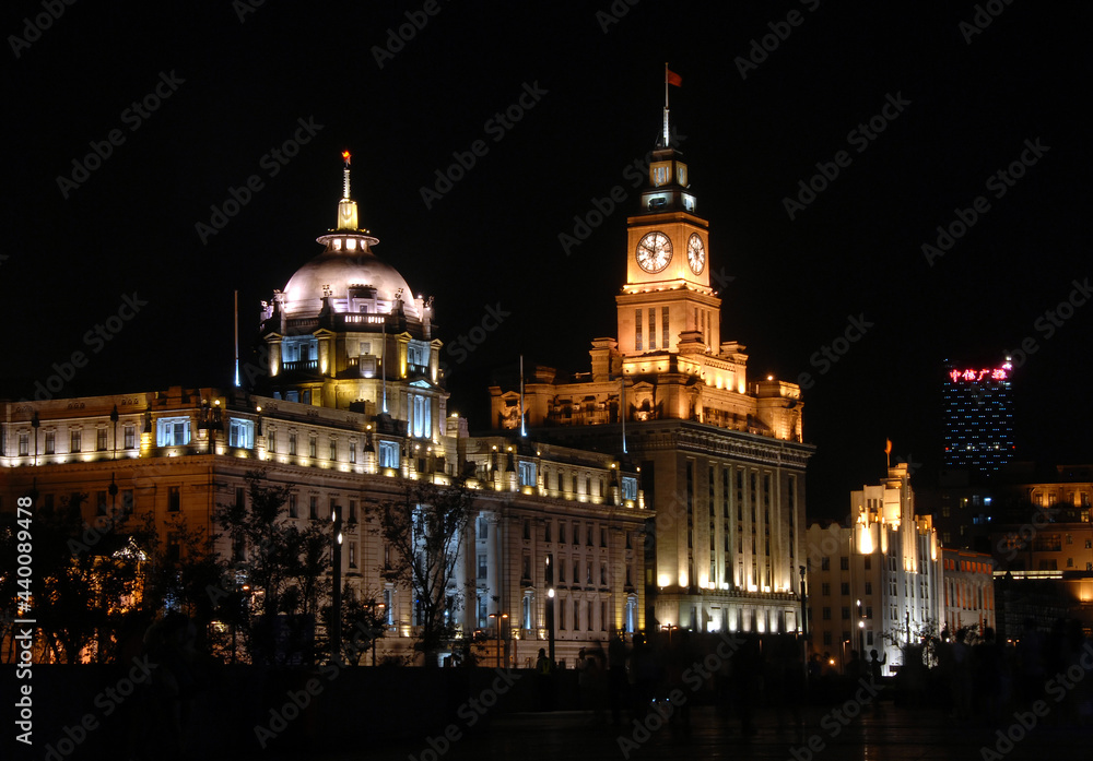 The Bund in Shanghai, China: View of illuminated colonial buildings at night along the Bund in Shanghai. The Bund is popular for tourists and local Shanghai people to walk at night. The Bund in Shanghai, China: View of illuminated colonial buildings at night along the Bund in Shanghai. The Bund is popular for tourists and local Shanghai people to walk at night.
