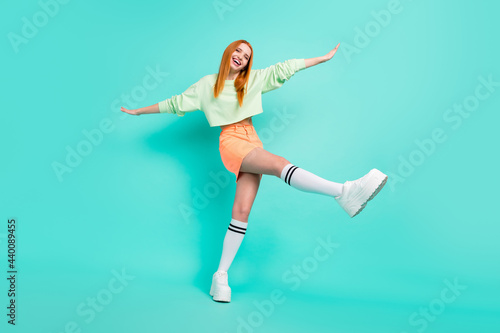 Fototapeta Naklejka Na Ścianę i Meble -  Full body photo of crazy millennial lady fly wear sport clothes skirt shoes isolated on teal color background