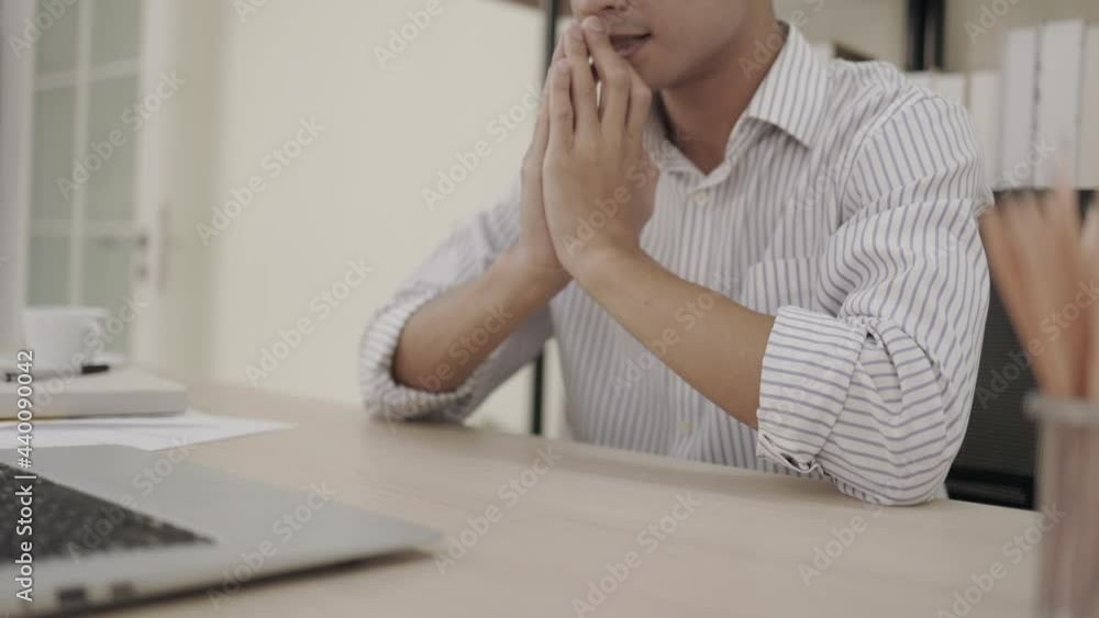 The stressed businessman put their hands in prayer pray and looking laptop with hope pondering reflecting concern about problem challenge sit at the office The stressed businessman put their hands in prayer pray and looking laptop with hope pondering reflecting concern about problem challenge sit at the office