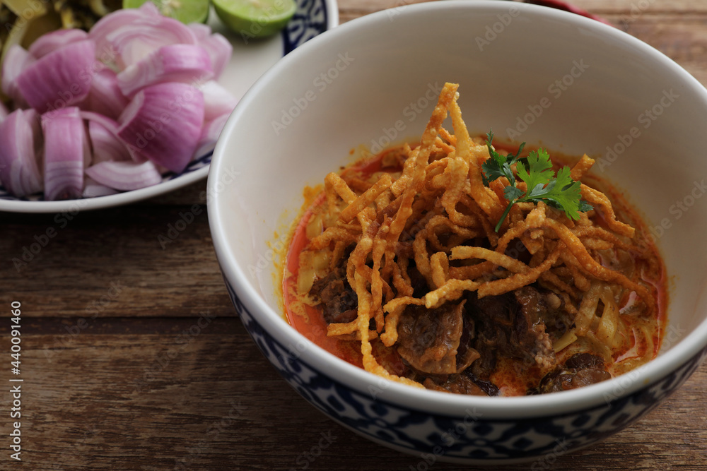Local northern Thai food Egg noodle curry with beef on wood background Local northern Thai food Egg noodle curry with beef on wood background