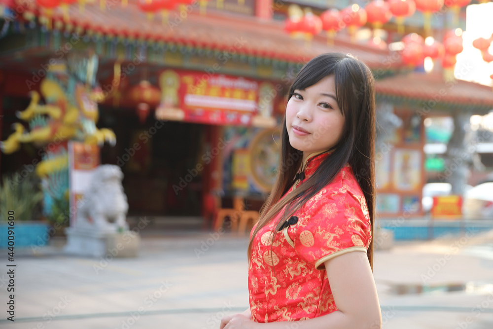 Fototapeta premium beauty woman wear red cheongsam looking and smile in chinese new year
