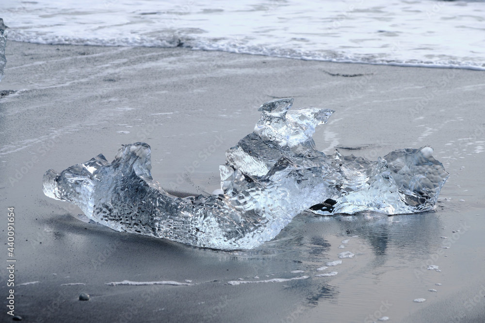 Obraz premium Ice Floes and chunks wash up on pristine black sand beaches on the southern Iceland Coast from melting and calved glaciers