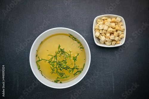 Broth with croutons on a dark table 