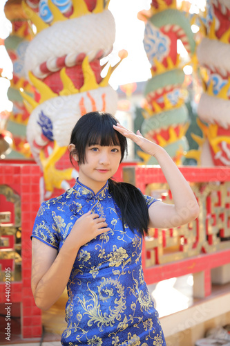 beauty woman wear blue cheongsam looking and smile in chinese new year