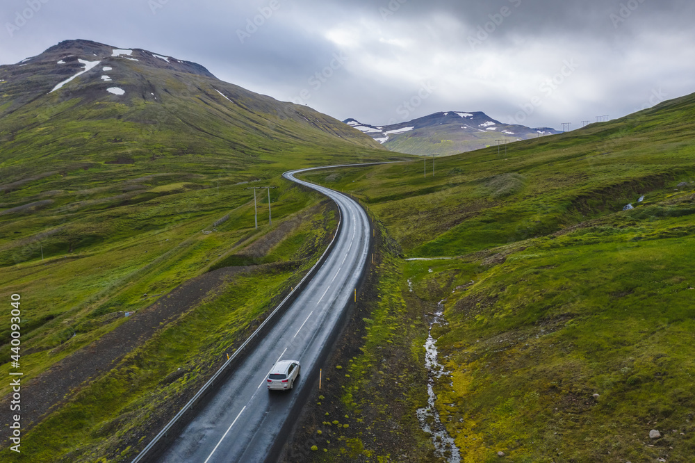 Lonely rent car drive on remote road with beautiful scenery of Iceland.