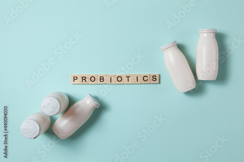 Bottles with probiotics and prebiotics dairy drink on light blue background. photo