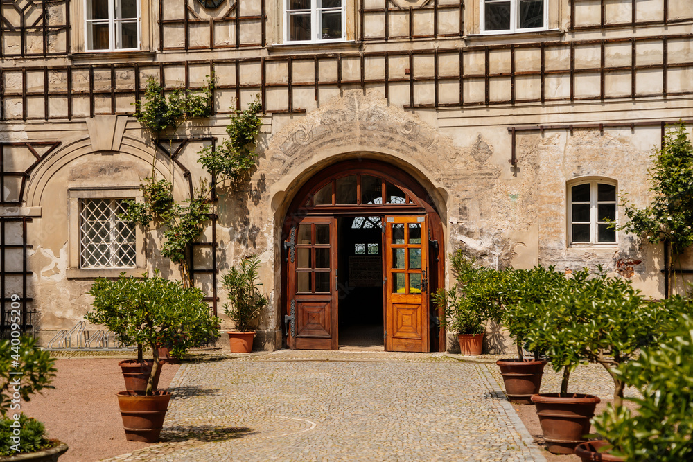 Baroque romantic castle Nove mesto nad Metuji, renaissance chateau, courtyard, Wooden lattice overgrown with greenery, sunny day, arched portal, entrance door, Bohemia, Czech Republic