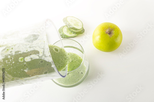 Smoothie recipe. Pouring green smoothie: spinach, apple, blender cucumber into glass. Home cooking. Vegan healthy detox eating, dietary and weght loss drink