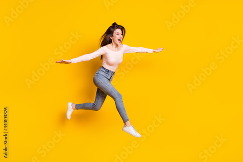 Full size photo of young crazy excited funky woman jumping flying look copyspace isolated on yellow color background