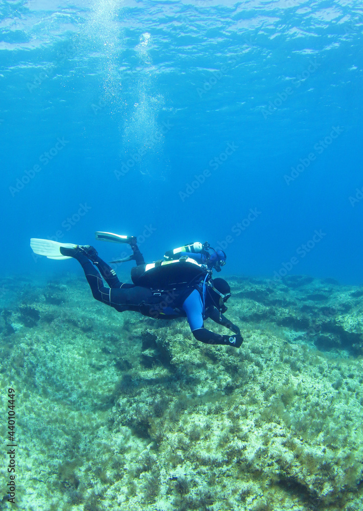 Diving instructor and student in underwater exercise. Instructor teaches student to dive. Underwater scuba diving education and training. Diving instructor and student in underwater exercise. Instructor teaches student to dive. Underwater scuba diving education and training.