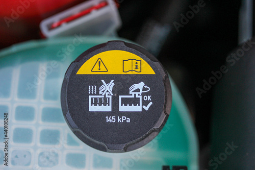 Vehicle coolant tank cap with warning label
