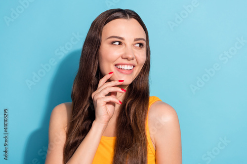 Photo portrait girl with long hair smiling looking copyspace touching cheeks isolated pastel blue color background