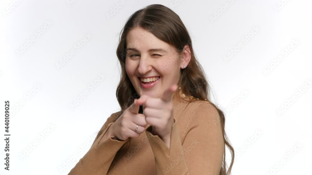 Studio portrait of happy smiling woman aiming in camera with fingers. Concept of winner, victory and success Studio portrait of happy smiling woman aiming in camera with fingers. Concept of winner, victory and success