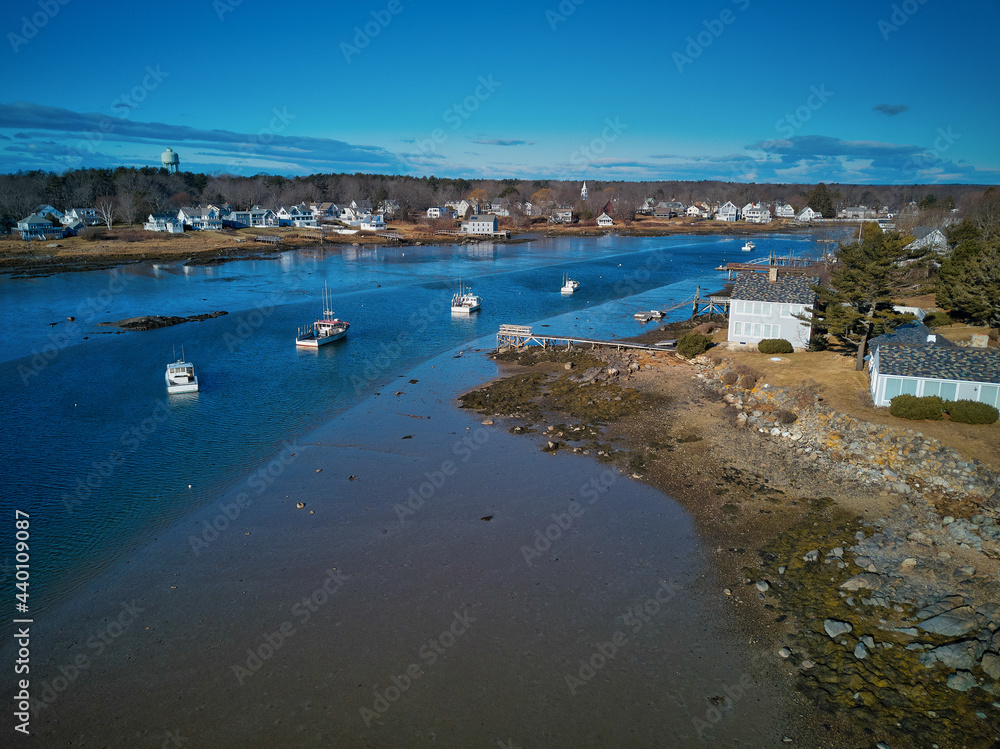Aerial drone image of low tide at the entrance to the Cape Porpoise Maine harbor on the New England coast on a perfect winter afternoon