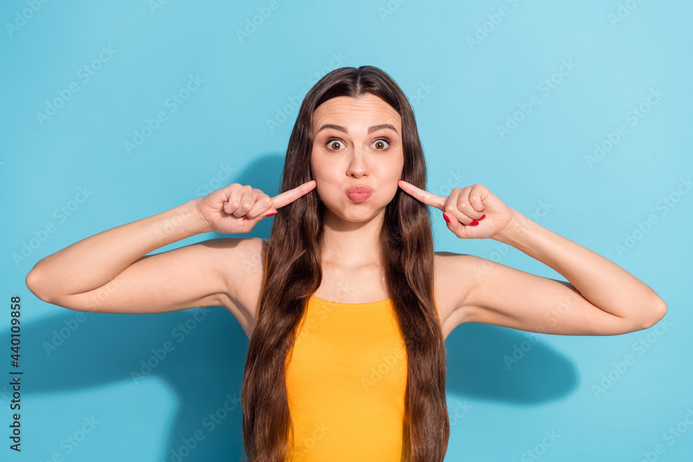 Photo portrait girl with long hair keeping air touching cheeks childish isolated pastel blue color background Photo portrait girl with long hair keeping air touching cheeks childish isolated pastel blue color background