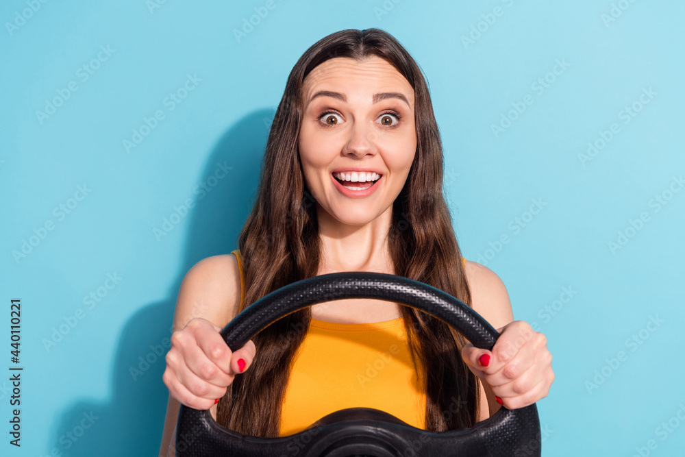 Photo portrait girl keeping steering wheel driving car first time isolated pastel blue color background Photo portrait girl keeping steering wheel driving car first time isolated pastel blue color background