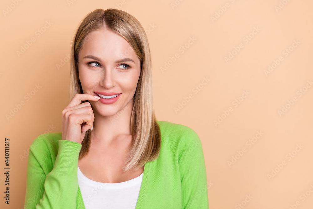 Photo portrait blonde woman smiling biting finger looking copyspace isolated pastel beige color background Photo portrait blonde woman smiling biting finger looking copyspace isolated pastel beige color background